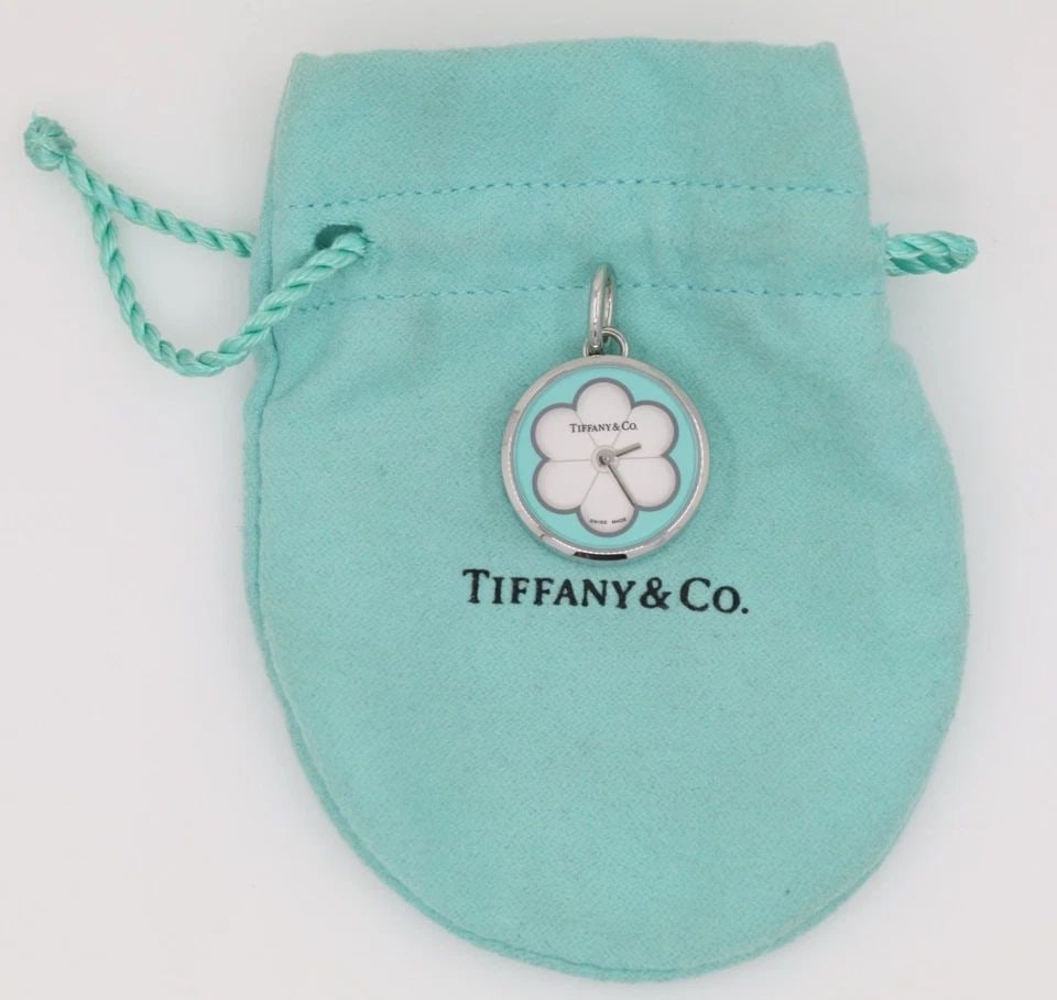 TIFFANY & CO STAINLESS STEEL WHITE BLOSSOM ENAMEL FLOWER DIAL WATCH PENDANT: TIFFANY & CO STAINLESS STEEL WHITE BLOSSOM ENAMEL FLOWER DIAL WATCH PENDANT Description Tiffany & Co Stainless Steel White Blossom Enamel Flower Dial Watch Pendant Pendant/watch is in good condition. 