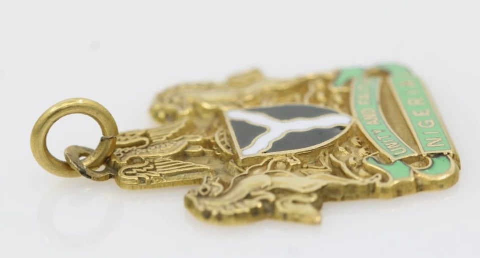 VINTAGE 9K COAT OF ARMS OF NIGERIA UNITY AND FAITH PENDANT 3 GRAMS: VINTAGE 9K COAT OF ARMS OF NIGERIA UNITY AND FAITH PENDANT 3 GRAMS Description Vintage 9K Coat of Arms of Nigeria Unity and Faith Pendant Pendant is in good condition. May show signs of wear. APPROXIM