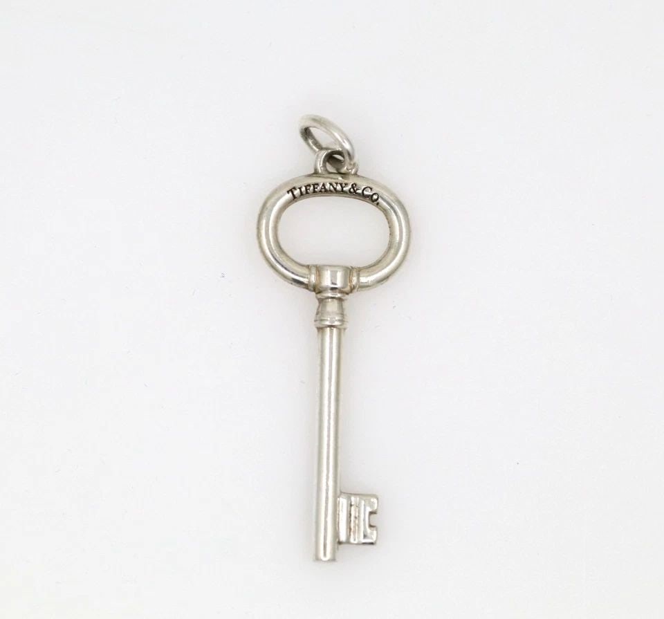TIFFANY & CO. STERLING SILVER OVAL KEY PENDANT CHARM 1.5" W/ POUCH: TIFFANY & CO. STERLING SILVER OVAL KEY PENDANT CHARM 1.5" W/ POUCH Description Tiffany & Co. Sterling Silver Oval Key Pendant Charm 1.5" w/ Pouch Item is in good condition. May show signs of wear and/