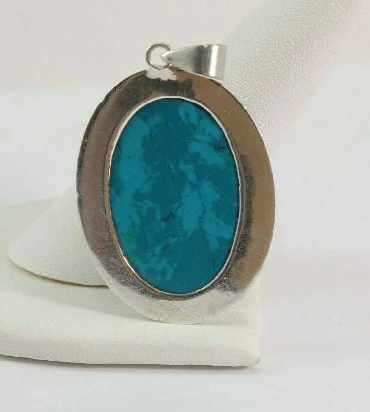 OVAL TURQUOISE & STERLING SILVER PENDANT 21 MM BY 30 MM ~ 10.4 GRAMS: OVAL TURQUOISE & STERLING SILVER PENDANT 21 MM BY 30 MM ~ 10.4 GRAMS Description Oval Turquoise & Sterling Silver Pendant Item is in great condition. May show signs of wear and/or tarnish. MEASURES AP