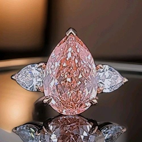 14K ROSE GOLD ENGAGEMENT RING 10.77CT LAB GROWN PINK DIAMOND PEAR SHAPE IGI: 14K ROSE GOLD ENGAGEMENT RING 10.77CT LAB GROWN PINK DIAMOND PEAR SHAPE IGI This stunning 14K rose gold engagement ring features a 10.77-carat lab-grown pear-shaped pink diamond, IGI certified. Measur