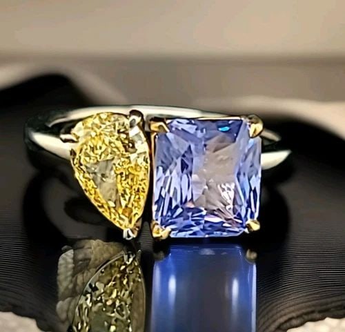 14K WHITE GOLD 3.43CT. NATURAL BLUE SAPPHIRE DIAMOND PEAR TOI ET MOI RING: This is a 14k white gold ring with a 2.53ct natural blue sapphire as the main stone. The sapphire is emerald shaped and has a prong setting. The ring also has one lab-grown yellow diamond as a seconda
