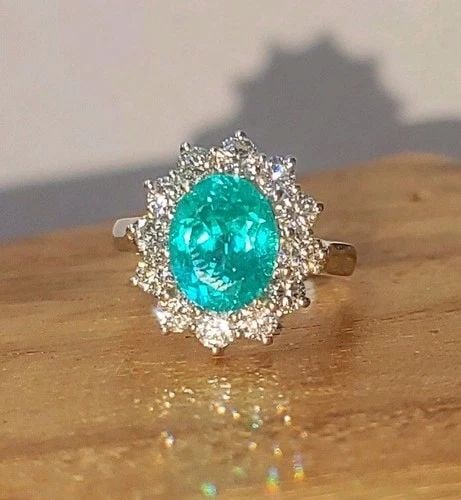 VINTAGE 18K WHITE GOLD ENGAGEMENT RING 4.02CT. NEON BLUE TOURMALINE OVAL SHAPE: VINTAGE 18K WHITE GOLD ENGAGEMENT RING 4.02CT. NEON BLUE TOURMALINE OVAL SHAPE Elegant 18K white gold engagement ring featuring a stunning lab-grown oval-cut Paraiba tourmaline weighing 4.02 carats, d