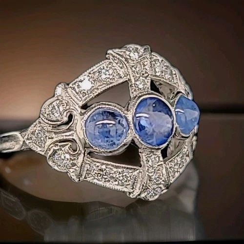 VINTAGE PLATINUM RING 1.35CT. NATURAL BLUE SAPPHIRE CABOCHON ROUND CIRC 1930'S: VINTAGE PLATINUM RING 1.35CT. NATURAL BLUE SAPPHIRE CABOCHON ROUND CIRC 1930'S This Vintage Platinum Ring from the 1930s features a stunning natural blue sapphire cabochon as the main stone, with a to