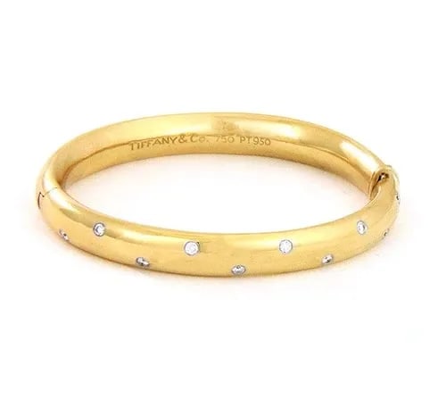 TIFFANY & CO. ETOILE DIAMOND GOLD BRACELET 18K YELLOW PLATINUM DOME HINGED: The Tiffany & Co. diamond and gold bracelet is from the Etoile Collection. It is a luxurious piece of fine jewelry that exudes beauty and elegance. Made with 18k yellow gold and platinum, this hinged 
