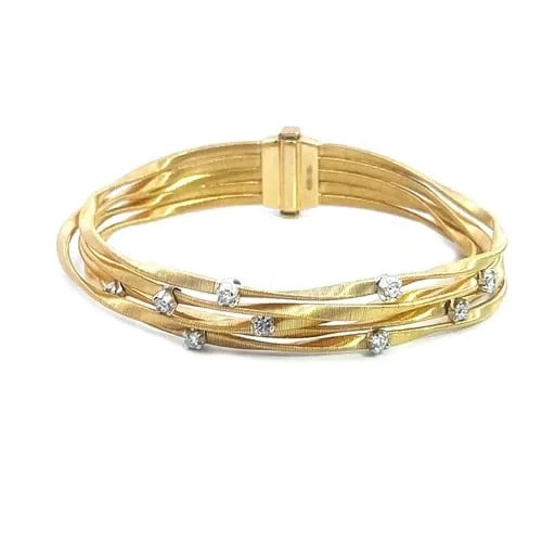 MARCO BICEGO MARRAKESH GOLD BRACELET DIAMOND 18K MOTIF 5 STRAND WAVE BAND: The Marco Bicego Marrakesh 18k yellow gold bracelet is a stunning piece of fine jewelry that features 5 unique cable style wave band accented with natural white diamonds on white gold prongs. The brac