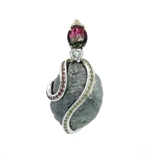69CT DIAMOND TOURMALINE SMALL DIAMOND & GEMS 18K GOLD PENDANT: 69CT DIAMOND TOURMALINE SMALL DIAMOND & GEMS 18K GOLD PENDANT This is a magnificent pendant, it features a large raw uncut 69 carat diamond held inside a curved ribbon strip of 18k white gold and has 