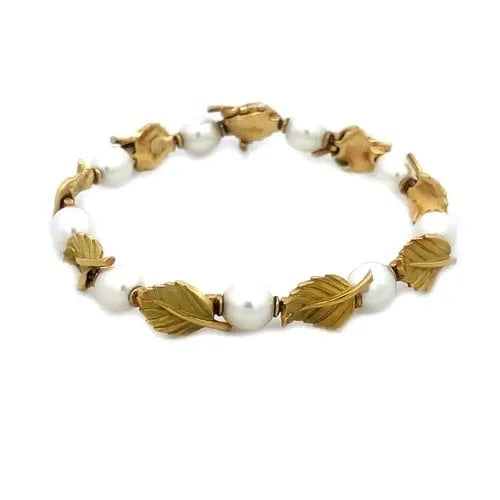 TIFFANY & CO. GOLD BRACELET 18K YELLOW OLIVE LEAF & PEARL LINK STYLE: The Tiffany & Co. Pearls Gold Bracelet is a luxurious piece of fine jewelry that features cultured white pearls set in 18k yellow gold. The pearls alternate with lovely detailed gold leaf links along 