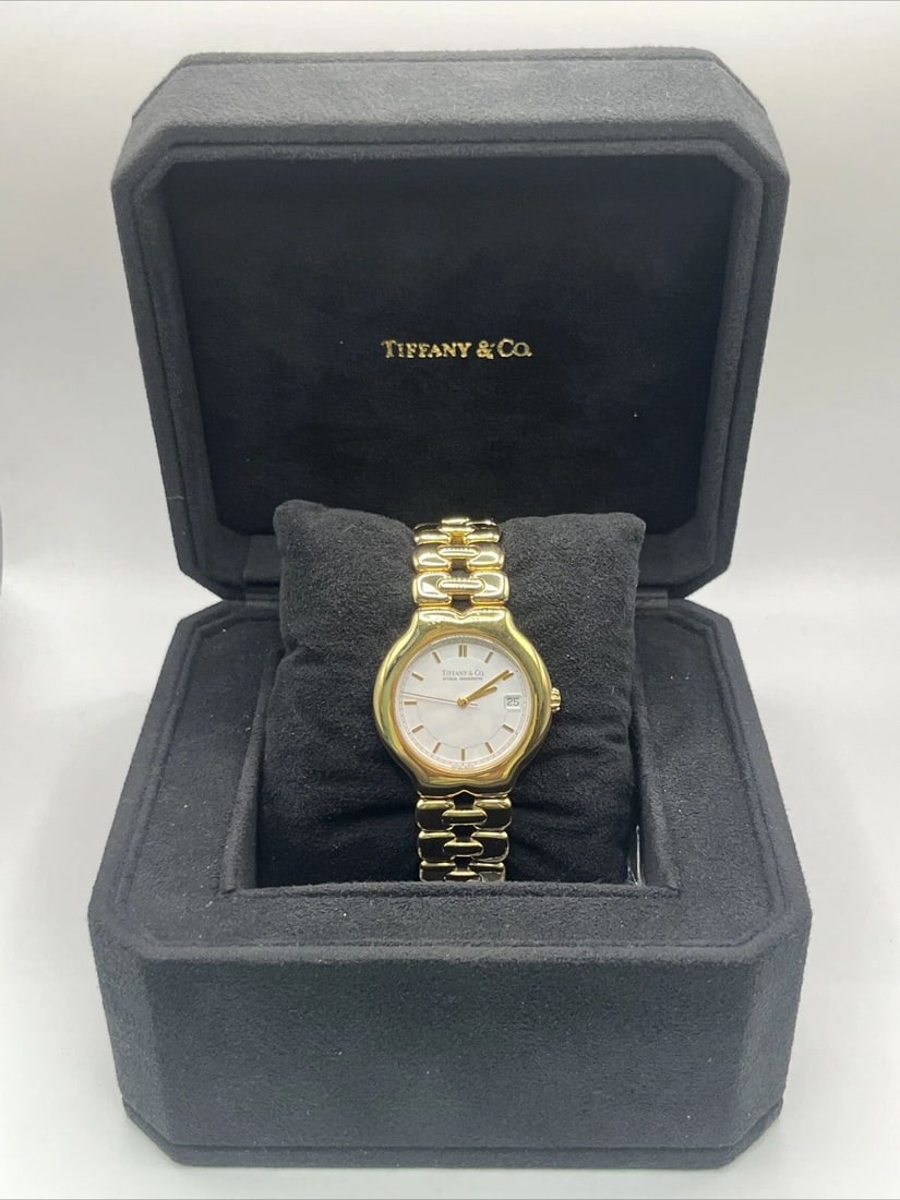 TIFFANY & CO. TESORO WATCH WITH ROUND WHITE FACE 18K YELLOW GOLD: TIFFANY & CO. TESORO WATCH WITH ROUND WHITE FACE 18K YELLOW GOLD TIFFANY & CO. TESORO WATCH WITH ROUND WHITE FACE 18K YELLOW GOLD This Tiffany & Co. Tesoro Quartz Watch with Round White Face 18K Yello