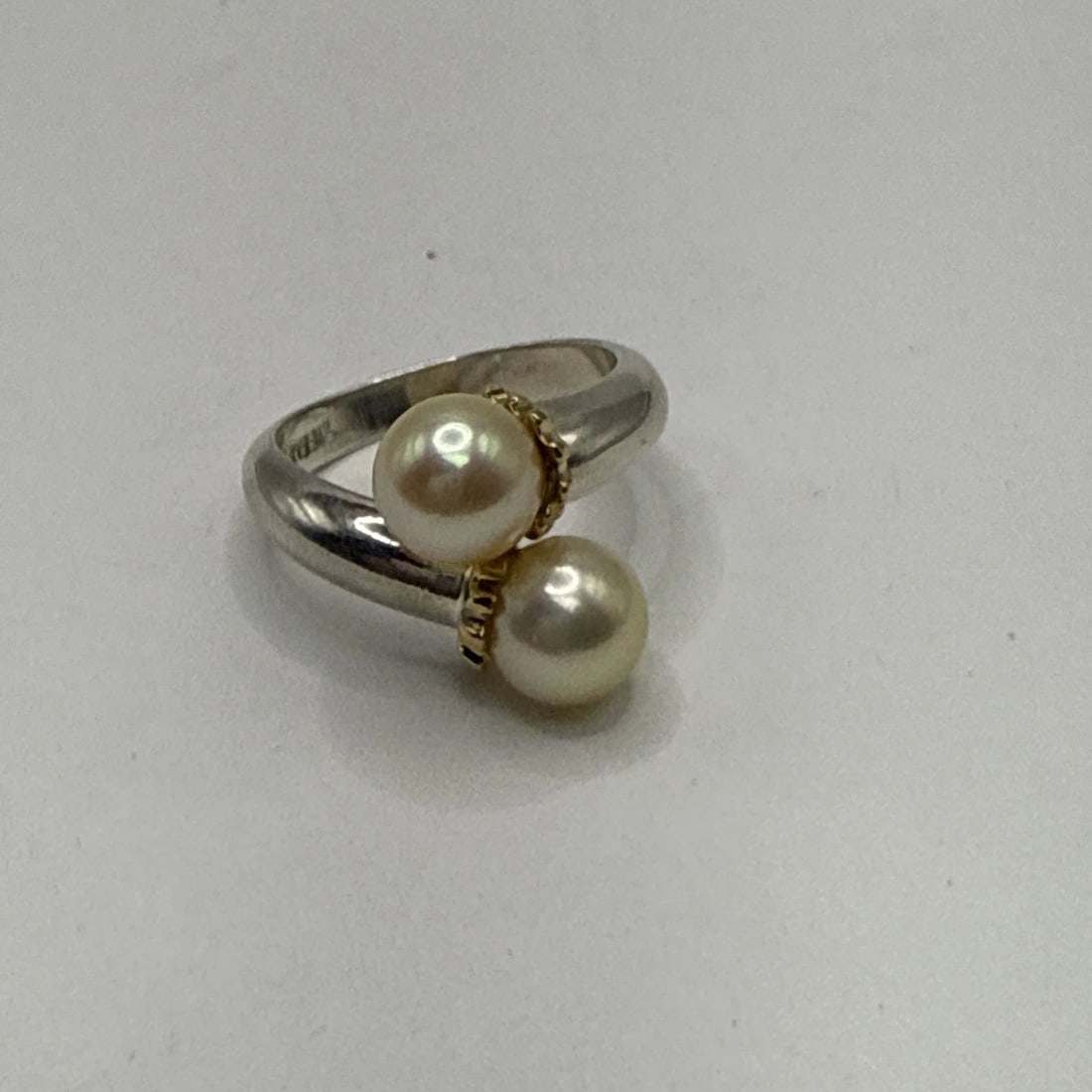TIFFANY & CO. STERLING SILVER BYPASS PEARL RING WITH 18K Y/G ACCENTS SIZE 6.75: TIFFANY & CO. STERLING SILVER BYPASS PEARL RING WITH 18K Y/G ACCENTS SIZE 6.75 The Tiffany & Co. Sterling Silver Bypass Pearl Ring is a luxurious and elegant piece of fine jewelry. Featuring a round p
