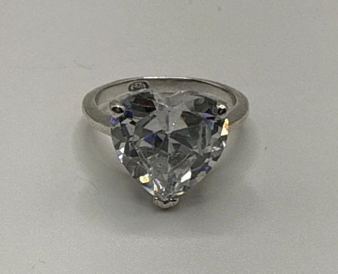 STERLING SILVER RING WITH COLORLESS HEART STONE SIZE 6: STERLING SILVER RING WITH COLORLESS HEART STONE SIZE 6 The Sterling Silver Ring with Colorless Heart Stone in size 6 is a beautiful piece of fine jewelry featuring a heart-shaped white/colorless stone
