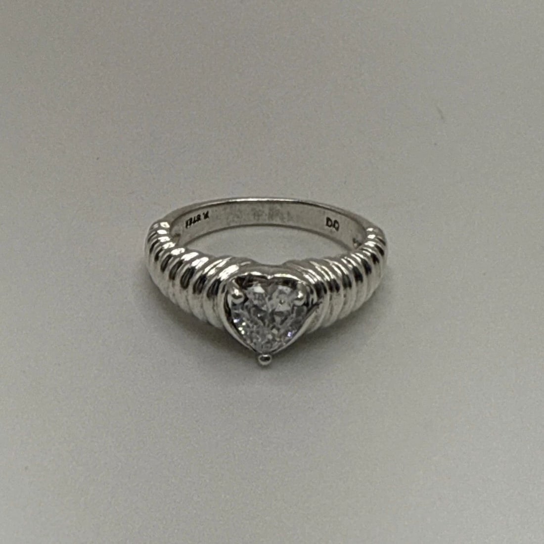STERLING SILVER RING WITH COLORLESS HEART STONE SIZE 6: STERLING SILVER RING WITH COLORLESS HEART STONE SIZE 6 This sterling silver ring features a colorless heart-shaped stone, making it a charming and elegant piece of fine jewelry. The ring is crafted wi
