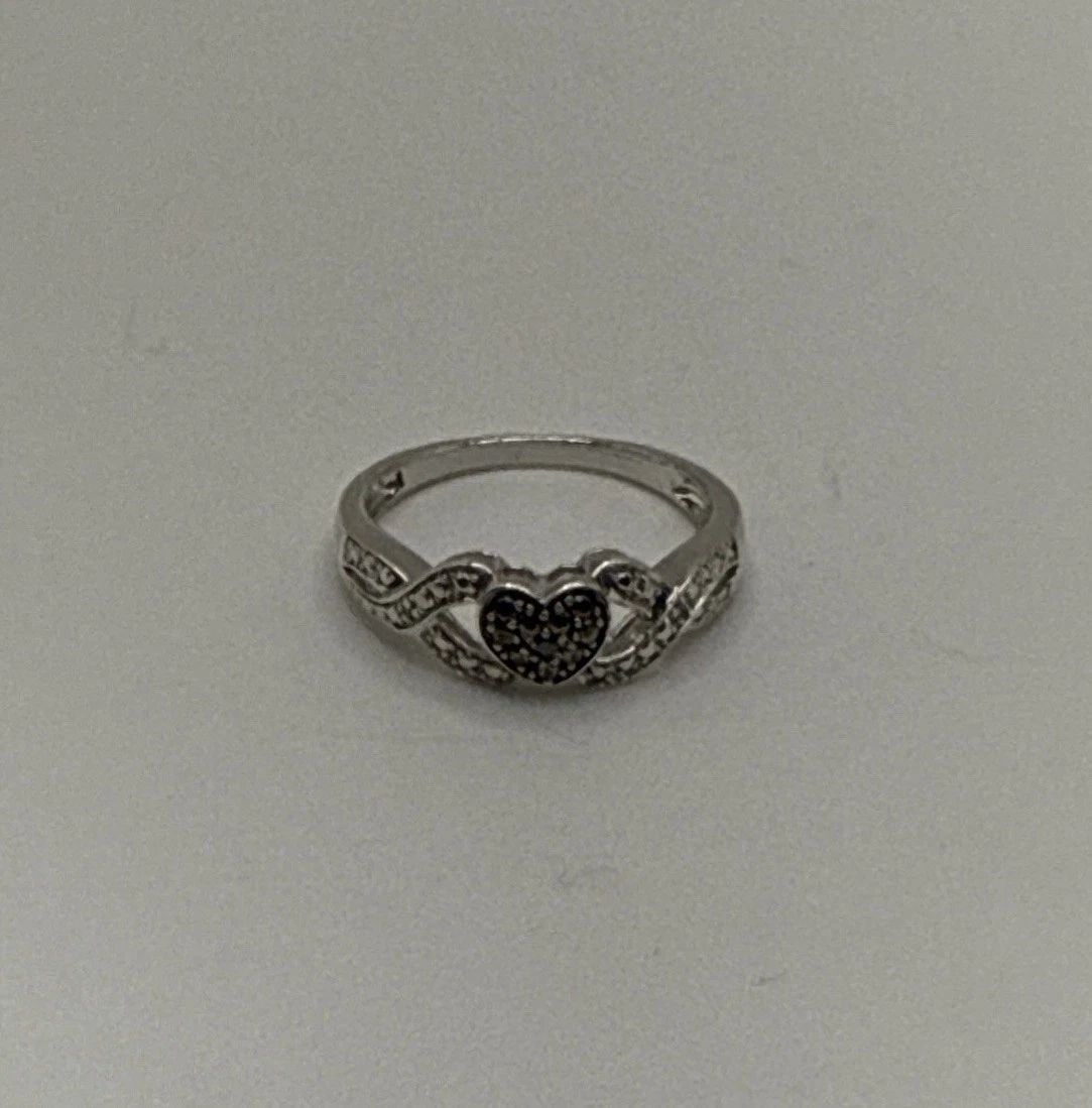STERLING SILVER RING WITH BLACK STONE HEART AND COLORLESS STONES SIZE 7: STERLING SILVER RING WITH BLACK STONE HEART AND COLORLESS STONES SIZE 7 This sterling silver ring features a black stone heart surrounded by colorless stones, all set in a high-quality 925 sterling si