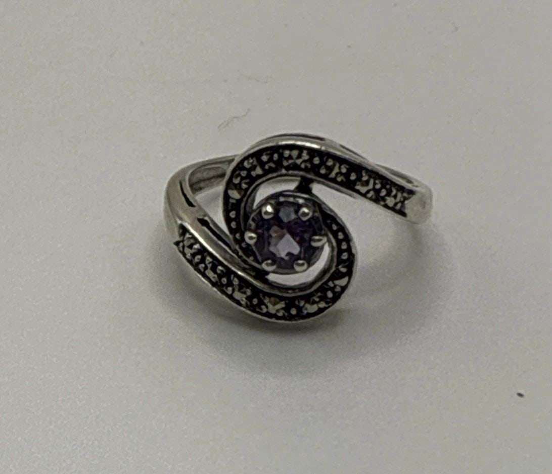 STERLING SILVER RING WITH PURPLE STONE & MARCASITE SIZE 5: STERLING SILVER RING WITH PURPLE STONE & MARCASITE SIZE 5 This Sterling Silver Ring with a Purple Stone & Marcasite is a stunning piece of fine jewelry. The ring is crafted with 925 sterling silver an