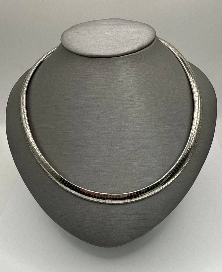 16" STERLING SILVER OMEGA CHAIN 32.2 GRAMS: 16" STERLING SILVER OMEGA CHAIN 32.2 GRAMS The product is a 16" sterling silver omega chain weighing 32.2 grams. It is a classic and elegant necklace featuring a chain style design. The high quality s