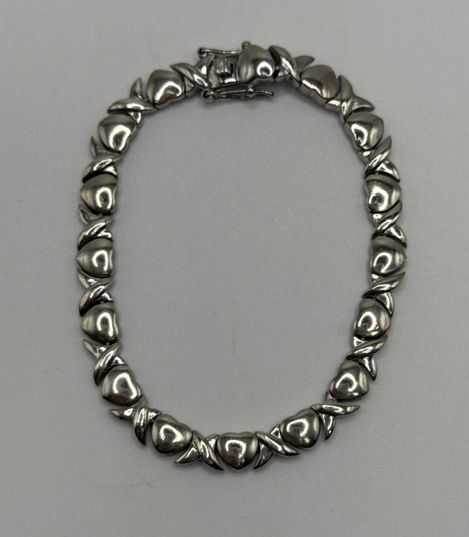 STERLING SILVER 7" X & HEART BRACELET 15.3 GRAMS: STERLING SILVER 7" X & HEART BRACELET 15.3 GRAMS This product is a stylish Sterling Silver X and Heart Bracelet, weighing 15.3 grams. The bracelet features a chain style design with a sterling silver 