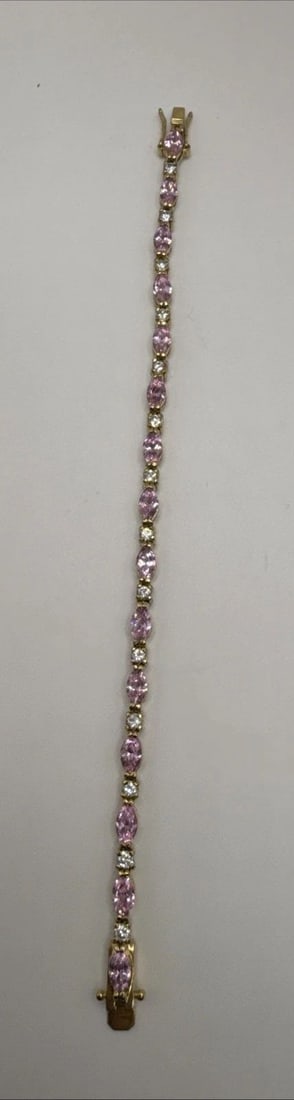 7" GOLD COLORED 925 BRACELET WITH PINK AND COLORLESS STONES: 7" GOLD COLORED 925 BRACELET WITH PINK AND COLORLESS STONES This 7" gold colored 925 bracelet features pink and colorless stones set in sterling silver. The tennis style bracelet is crafted with high-