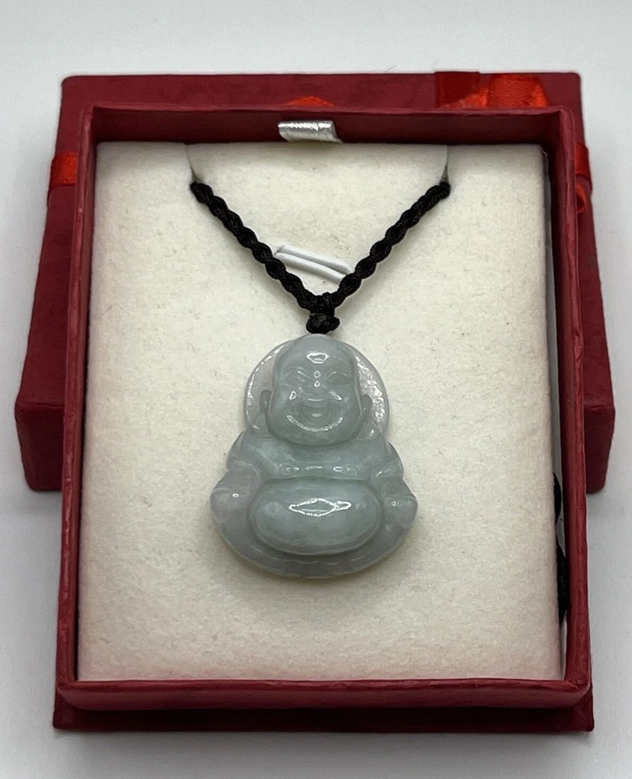 JADE HAPPY BUDDAH NECKLACE ON 21" BLACK ROPE: JADE HAPPY BUDDAH NECKLACE ON 21" BLACK ROPE JADE HAPPY BUDDAH NECKLACE ON 21" BLACK ROPE This beautiful necklace features a happy Buddha pendant made of jade, set on a 21" black rope. The pendant is 