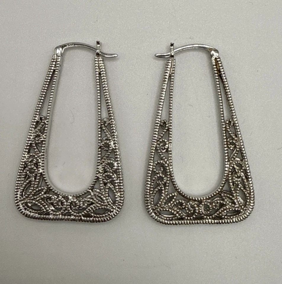 FILIGREE LARGE HOOP EARRINGS 9.6 GRAMS: FILIGREE LARGE HOOP EARRINGS 9.6 GRAMS The product is a pair of large hoop earrings made of sterling silver with a metal purity of 925. These earrings are designed in a filigree style, which means the