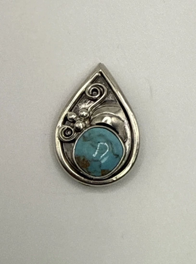 STERLING SILVER & TURQUOISE PIN/PENDANT 4.7 GRAMS: STERLING SILVER & TURQUOISE PIN/PENDANT 4.7 GRAMS This product is a sterling silver pendant featuring a beautiful turquoise stone, showcasing a vibrant blue color. The pendant is crafted with 925 ster