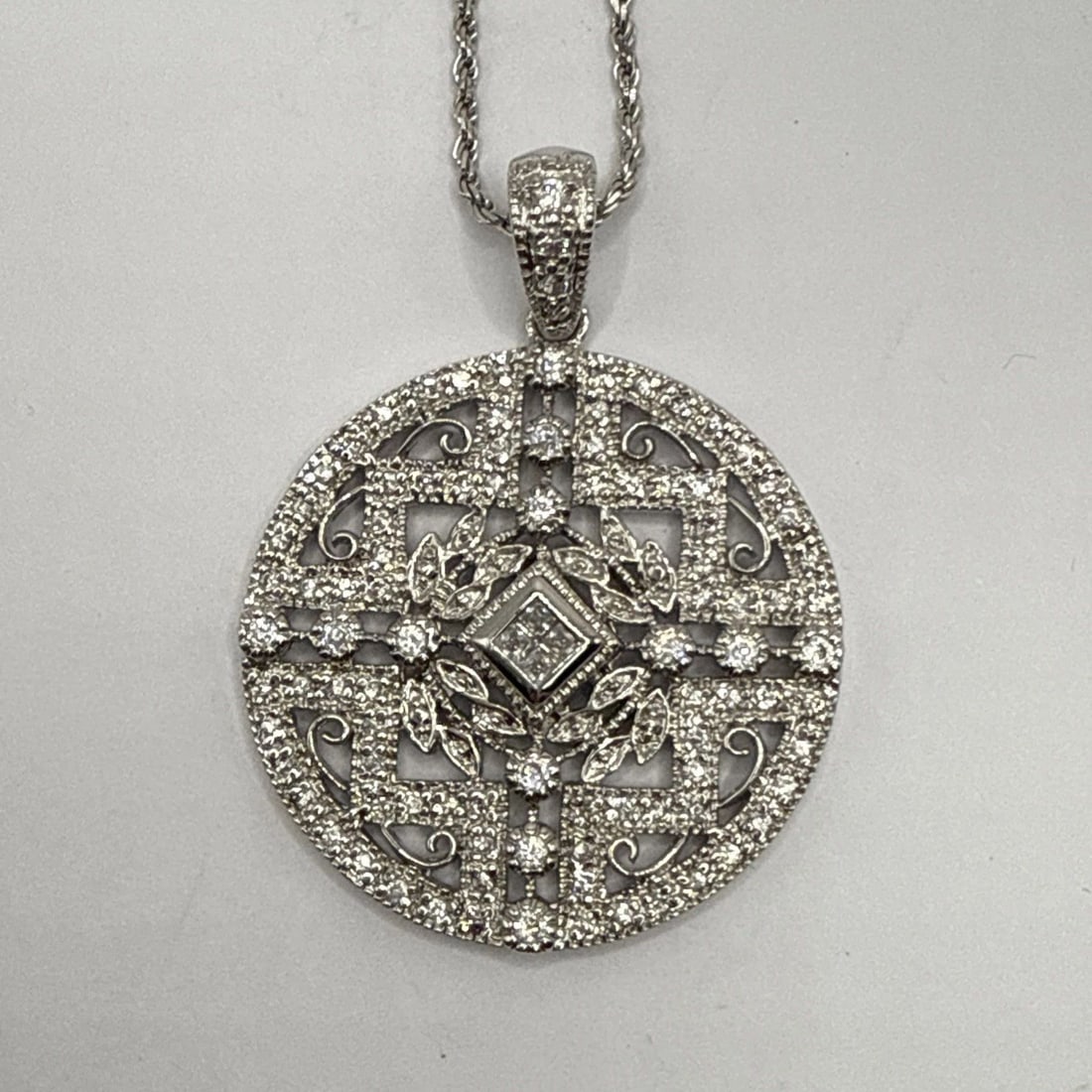 925 ROUND FLORAL DESIGN CZ CRYSTAL PENDANT ON 30" STERLING SILVER ROPE CHAIN: 925 ROUND FLORAL DESIGN CZ CRYSTAL PENDANT ON 30" STERLING SILVER ROPE CHAIN The product is a 925 sterling silver pendant with a floral design featuring colorless cubic zirconium crystals. It comes wi