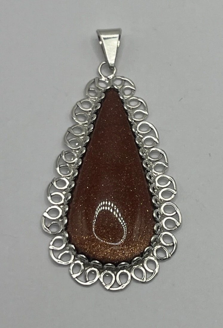 STERLING SILVER TEARDROP PENDANT WITH BROWN STONE: STERLING SILVER TEARDROP PENDANT WITH BROWN STONE STERLING SILVER TEARDROP PENDANT WITH BROWN STONE This Sterling Silver Teardrop Pendant features a beautiful brown stone as its main focal point. The 