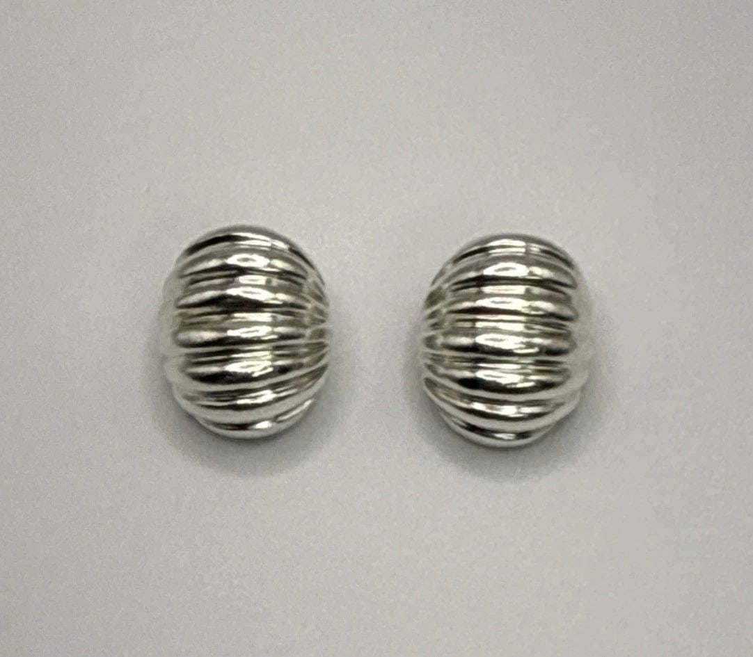 STERLING SILVER RIDGED CLIP-ON EARRINGS These Sterling Silver Ridged Clip-On Earrings feature a: These Sterling Silver Ridged Clip-On Earrings feature a classic stud style with a sleek silver color and a secure clip-on closure. Crafted from high-quality 925 sterling silver, these earrings offer a