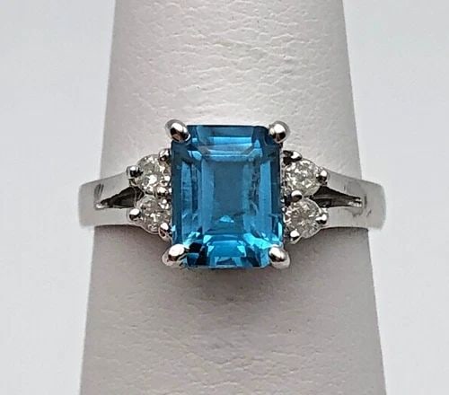 NEW 14K WHITE GOLD RING WITH BLUE TOPAZ, 0.15CTW DIAMONDS (SIZE: 5.75) 3.1 GRAMS: 14K WHITE GOLD RING WITH CENTER BLUE TOPAZ, AND 0.15CTS OF DIAMONDS SIZE: 5.75 14k White Gold Ring with center Blue Topaz, and 0.15cts of Diamonds Condition: New with Tags Material: 14k White Gold Rin