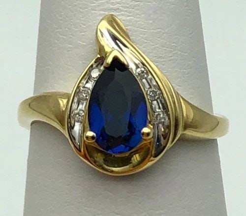 10K GOLD RING PEAR CUT LAB CREATED SAPPHIRE, 0.06CTS DIAMONDS (SIZE 7) 2.9G: 10K GOLD RING PEAR SHAPED LAB CREATED SAPPHIRE AND 0.06CTS DIAMONDS SIZE: 7 10k Gold Ring pear shaped Lab created Sapphire and 0.06cts of Diamonds Condition: Used Material: 10k Yellow Gold Ring Size: 