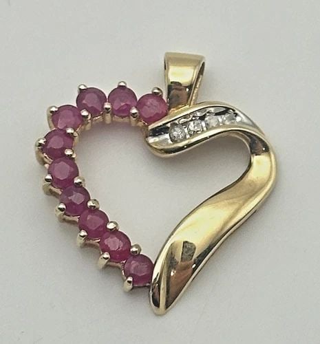 10K GOLD HEART PENDANT WITH 1.6CTW RUBIES AND 0.04CTW DIAMONDS 1.9 GRAMS: 10K GOLD HEART PENDANT WITH 1.6CTS OF RUBIES AND 0.04CTS OF DIAMONDS 1.9 GRAMS 10k Gold Heart Pendant with 1.6cts of Rubies and 0.04cts of Diamonds Condition: Used Material: 10k Yellow Gold Pendant Si