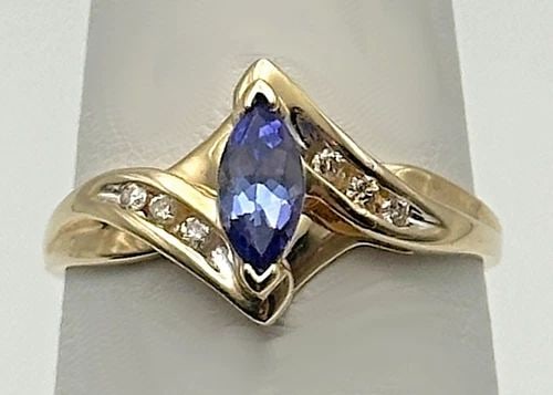 10K GOLD RING WITH MARQUISE TANZANITE AND 0.06CTW DIAMONDS (SIZE 7) 1.9 GRAM: 10K GOLD RING WITH TANZANITE AND 0.06CTS OF DIAMONDS SIZE: 7 10k Gold Ring with Tanzanite and 0.06cts of Diamonds Condition: Used, has been cleaned Material: 10k Yellow Gold Ring Size: 7 Weight: 1.9 g