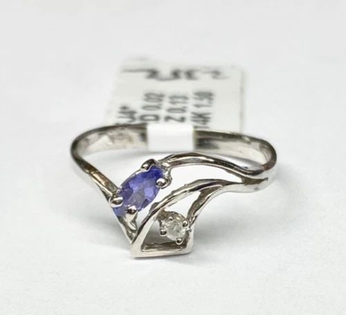 NEW WOMEN'S 14K WHITE GOLD RING WITH TANZANITE AND DIAMOND (SIZE 5.25) 1.5 GRAMS: WOMEN'S 14K WHITE GOLD RING WITH 0.13CT TANZANITE AND 0.02CT DIAMOND (SIZE 5.25) Women's 14k White Gold Ring with 0.13CT Tanzanite and 0.02CT Diamond (Size 5.25) You are bidding on a new with defects 