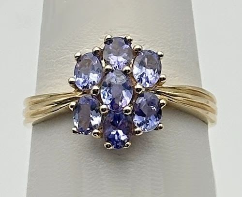 10K GOLD FLORAL STYLE RING WITH SEVEN TANZANITE (SIZE 8) 2 GRAM: 10K GOLD FLORAL STYLE RING WITH SEVEN TANZANITE STONES SIZE: 8 2.0 GRAMS 10k Gold Floral style Ring with Seven Tanzanite Stones Condition: Used, has been cleaned by our in house Jewelers Material: 10k
