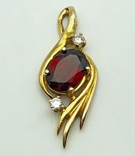 14K GOLD PENDANT WITH GARNET AND 0.08CTW NATURAL DIAMONDS 1.7 GRAMS: 14K GOLD PENDANT WITH GARNET AND 0.08CTS OF DIAMONDS 1.7 GRAMS 14k Gold Pendant with Garnet and 0.08cts of Diamonds Condition: Used Material: 14k Yellow Gold Pendant Size: 25mm x 10mm Total Weight: 1.