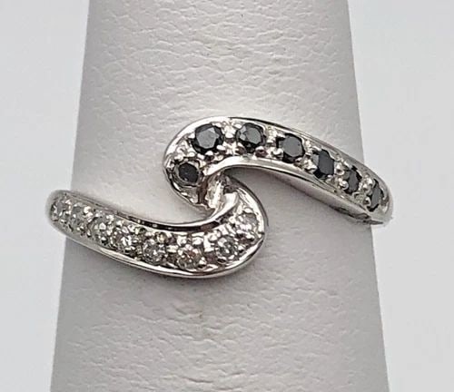 NEW 14K WHITE GOLD CURVED RING 0.15CTW BLACK/WHITE DIAMONDS (SIZE:5.25) 1.5 GRAM: 14K WHITE GOLD CURVED RING WITH BLACK AND WHITE DIAMONDS 0.15CTW SIZE: 5.25 14k White Gold Curved Ring with Black and White Diamonds 0.15ctw Condition: New with original Tag Material: 14k White Gold R