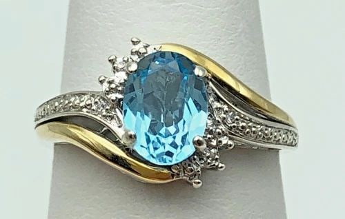 SILVER RING, 10K GOLD SIDES, BLUE TOPAZ, 0.01CTW DIAMONDS (SIZE 7.25) 2.8 GRAM: Silver Ring, 10k Gold accents, Blue Topaz and 0.01cts of Diamonds Condition: Used Material: 925 Sterling Silver / 10k Yellow Gold Ring Size: 7.25 Weight: 2.8 grams Top Width: 11mm Bottom Width: 1.6mm 
