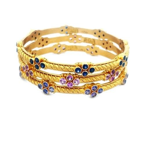 CAROLYN TYLER GOLD 22K SET OF 3 BANGLES GEMSTONES FLORAL MOTIFS: CAROLYN TYLER GOLD 22K SET OF 3 BANGLES GEMSTONES FLORAL MOTIFS This set of 3 bangles by Carolyn Tyler is crafted from 22k yellow gold and adorned with colorful gemstones and floral motifs. The bangle