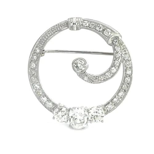 ART DECO DIAMOND BROOCH PLATINUM 2CT EUROPEAN CUT CURLED WREATH DESIGN: This magnificent eye-catching Art Deco brooch features a stunning design of curled wreath with larger European Cut Oval Diamond as the center stone with a round diamond on each side, all diamonds are 