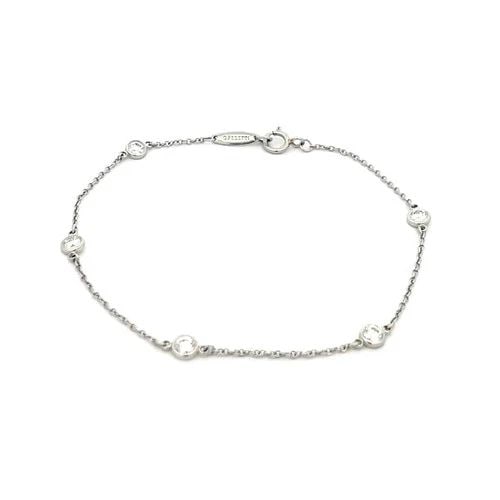 TIFFANY & CO. DIAMOND BY THE YARD BRACELET PERETTI PLATINUM 5 BEZEL PAPER: TIFFANY & CO. DIAMOND BY THE YARD BRACELET PERETTI PLATINUM 5 BEZEL PAPER The Tiffany & Co. Diamond by the Yard Bracelet in platinum features 5 round natural white diamonds set in a bezel style. It ha