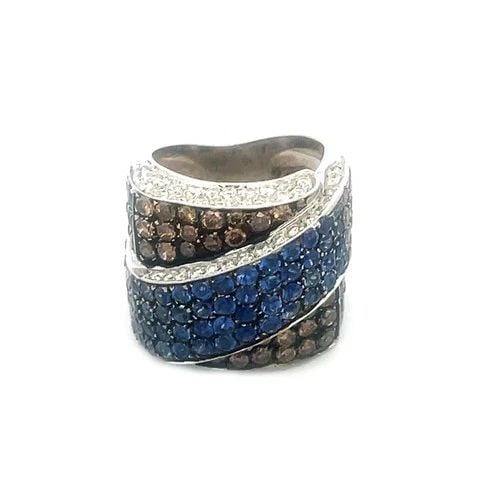 DIAMOND SAPPHIRE GOLD RING 18K WHITE HEAVY RIBBON CROSSOVER STYLE: DIAMOND SAPPHIRE GOLD RING 18K WHITE HEAVY RIBBON CROSSOVER STYLE This is a gorgeous diamond and sapphire wide band ring. It is a stunning piece of fine jewelry featuring a beautiful wide ribbon cross