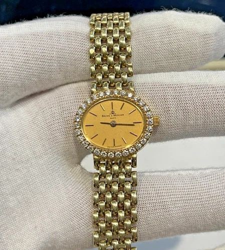 BAUME & MERCIER LADES WATCH, 14K GOLD, DIAMONDS 34.9 GRAMS: BAUME & MERCIER LADES 14KT GOLD AND DIAMOND WATCH Baume & Mercier Ladies 14kt gold, diamond bezel Watch RETAIL PRICE: $8900.00 You are bidding on a pre-owned Baume & Mercier Swiss made watch. The watc