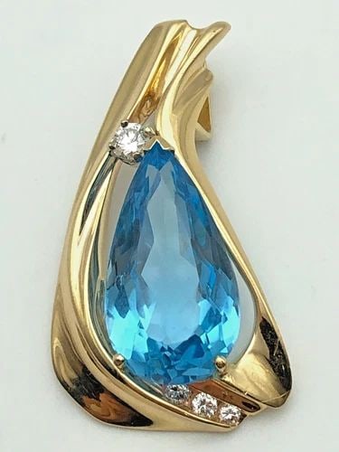 14K GOLD PENDANT WITH SWISS BLUE TOPAZ AND 0.18CTS OF DIAMONDS ( 8.5 GRAMS ): 14K GOLD PENDANT WITH SWISS BLUE TOPAZ AND 0.18CTS OF DIAMONDS 8.5 GRAMS 14k Gold Pendant with Swiss Blue Topaz and 0.18cts of Diamonds Condition: Used Material: 14k Yellow Gold Pendant Size: 37mm x 2