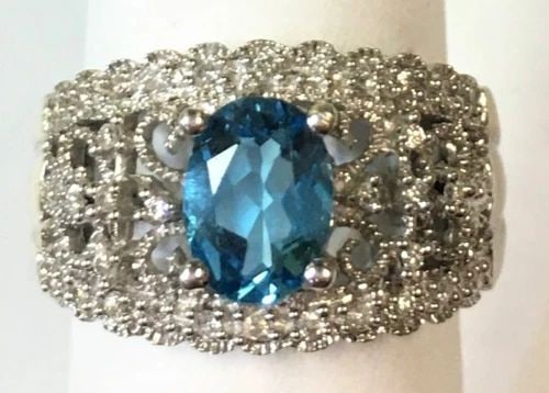 14K WHITE GOLD RING WITH BLUE TOPAZ AND 0.16CTW DIAMONDS (SIZE 6.75) 5.3 GRAM: 14K WHITE GOLD FILIGREE STYLE RING WITH CENTER OVAL BLUE TOPAZ AND DIAMONDS 14k White Gold Filigree style Ring with center oval Blue Topaz and Diamonds You are bidding on a 14k White Gold Filigree sty