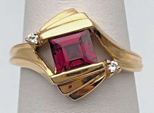 14K GOLD RING SET WITH GARNET AND 0.02CTS OF DIAMONDS (SIZE 6.75) 4.5 GRAMS: 14K GOLD RING SET WITH GARNET AND 0.02CTS OF DIAMONDS SIZE: 6.75 14k Gold Ring set with center Garnet and 0.02cts of Diamonds Condition: Used, Display model Material: 14k Yellow Gold Ring Size: 6.75 W