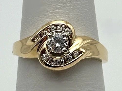 14K GOLD TWIST STYLE RING WITH 0.35CTW VS DIAMONDS (SIZE 6.25) 3.6 GRAM: 14k Gold center twist style Ring set with 0.35cts of Diamonds Condition: Used, has been cleaned Material: 14k Yellow Gold Ring Size: 6.25 Weight: 3.6 grams Top Width: 9.5mm Bottom Width: 1.6mm Stone I