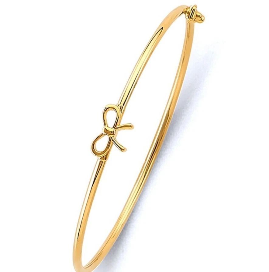 NEW 14K YELLOW GOLD BABY FLEXIBLE BANGLE WITH BOW RIBBON: NEW 14K YELLOW GOLD BABY FLEXIBLE BANGLE WITH RIBBON FLEXIBLE BANGLE WITH RIBBON NEW 14K YELLOW GOLD LENGTH - 7in Apx WEIGHT - 2g .