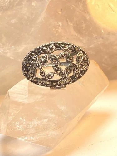 POISON RING MARCASITE FLORAL STERLING SILVER WOMEN: POISON RING MARCASITE FLORAL STERLING SILVER WOMEN Poison ring marcasite floral sterling silver women Opens up but there is no bottom to the locket Size 7.75 Weight 10g Length 1" Width 13/4" Thinnest 