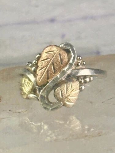 BLACK HILLS GOLD RING LEAVES BAND SIZE 10 STERLING SILVER WOMEN: BLACK HILLS GOLD RING LEAVES BAND SIZE 10 STERLING SILVER WOMEN Black Hills Gold ring leaves band size 10 sterling silver women Size. 10. Detailed with 12K over sterling silver leaves Weight 5.2g Leng