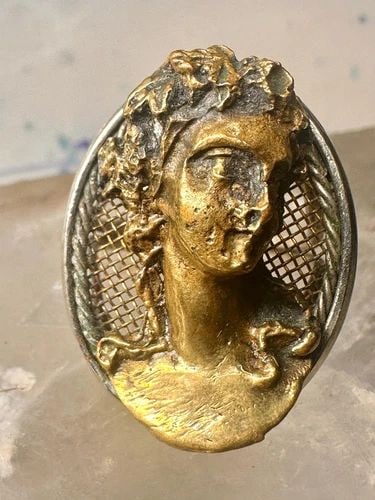 CLASSICAL FACE RING BAND SIZE 7.25 WOMEN: CLASSICAL FACE RING BAND SIZE 7.25 WOMEN Classical face ring band size 7.25 women The band is unmarked appears to be silver and the face appears to be bronze but unmarked Size 7.25 Between a size 7.25