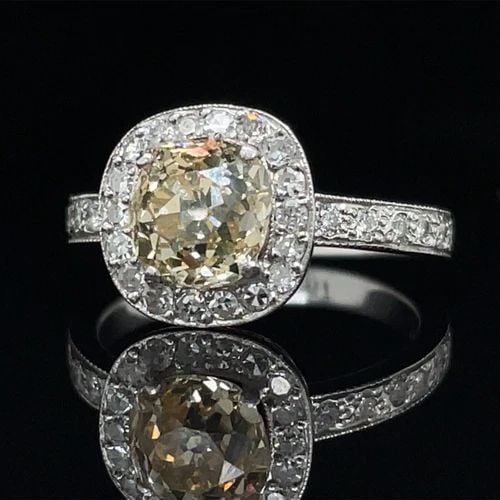 1.50CT CUSHION CUT DIAMOND RING IN PLATINUM WITH DIAMOND HALO AND HEART GALLERY: 1.50CT CUSHION CUT DIAMOND RING IN PLATINUM WITH DIAMOND HALO AND HEART GALLERY A Lovely Champagne Diamond Ring set in Platinum! Featuring a 1.50-Carat, Champagne Colored, Antique Cushion Cut Center (